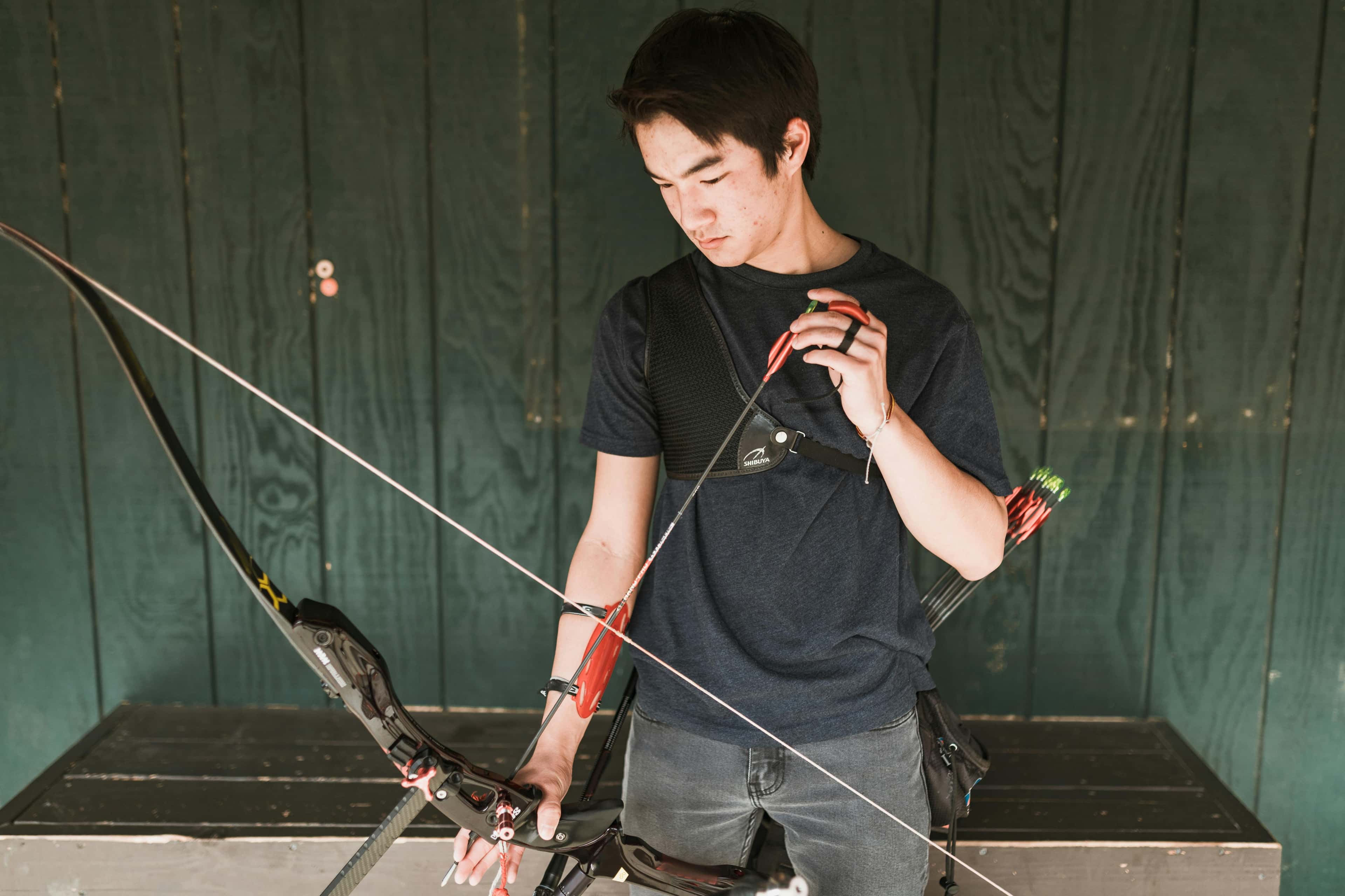 Custom archery socks category cover image showing athlete aiming on an outdoor range