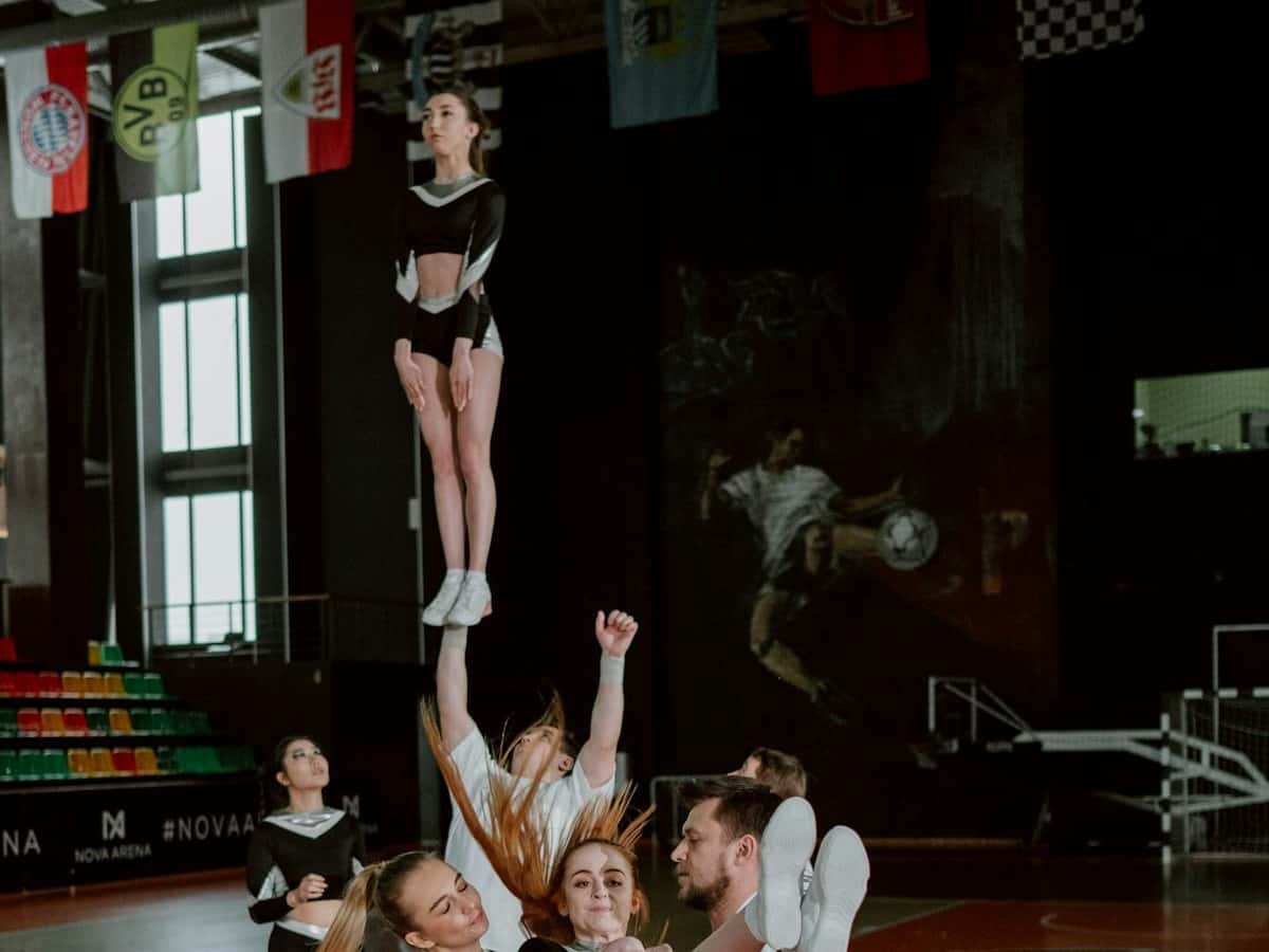Custom cheerleading socks category cover image showing stunt team in an indoor arena