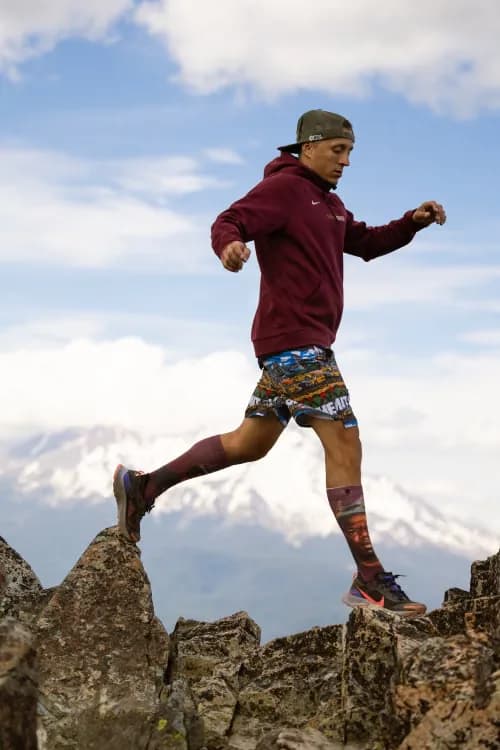 Trail runner crossing a rocky mountain ridge