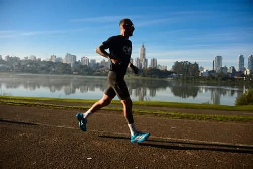 Runner moving beside a city lake