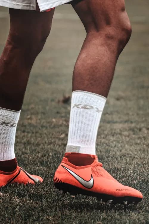 White baseball socks and orange cleats on the field