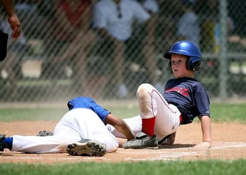 Youth baseball player sliding into a base