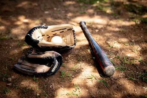 Baseball gloves and bat on the field