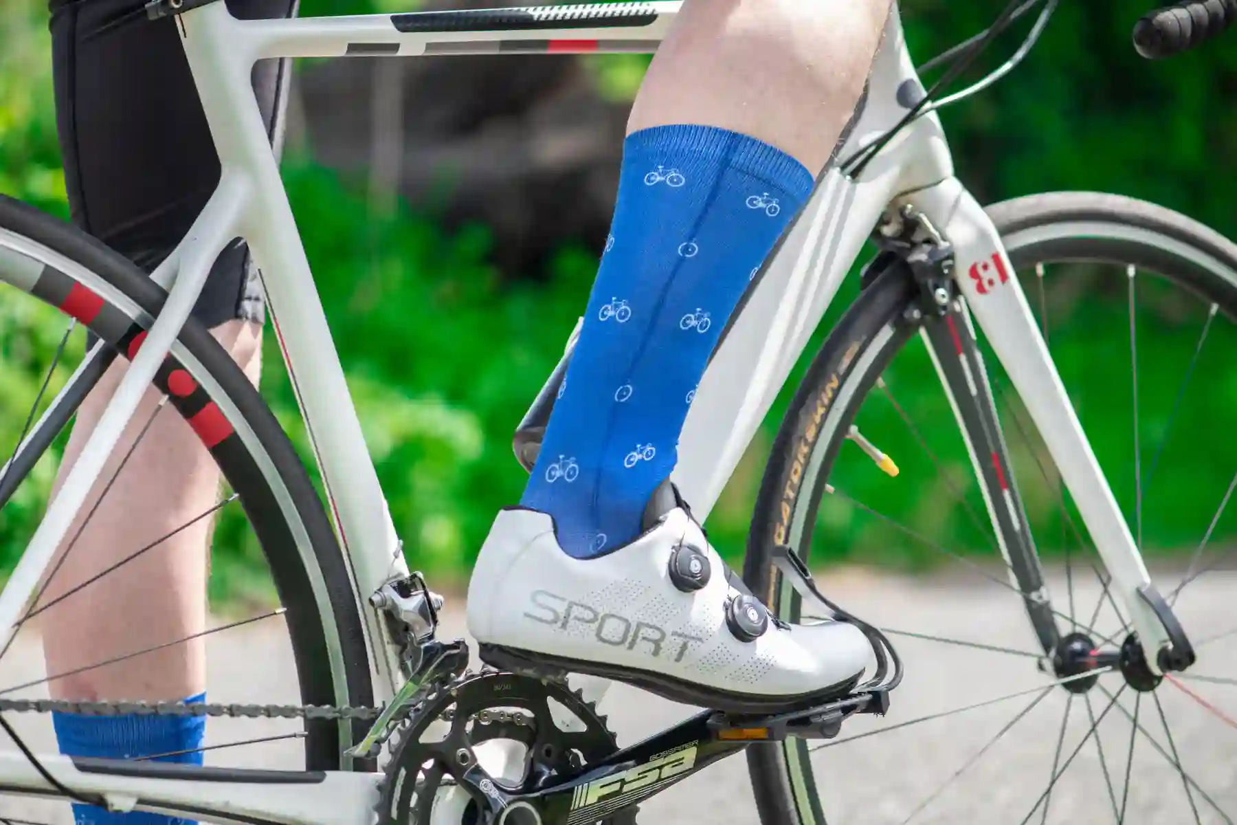 Cyclist wearing blue socks while riding a road bike