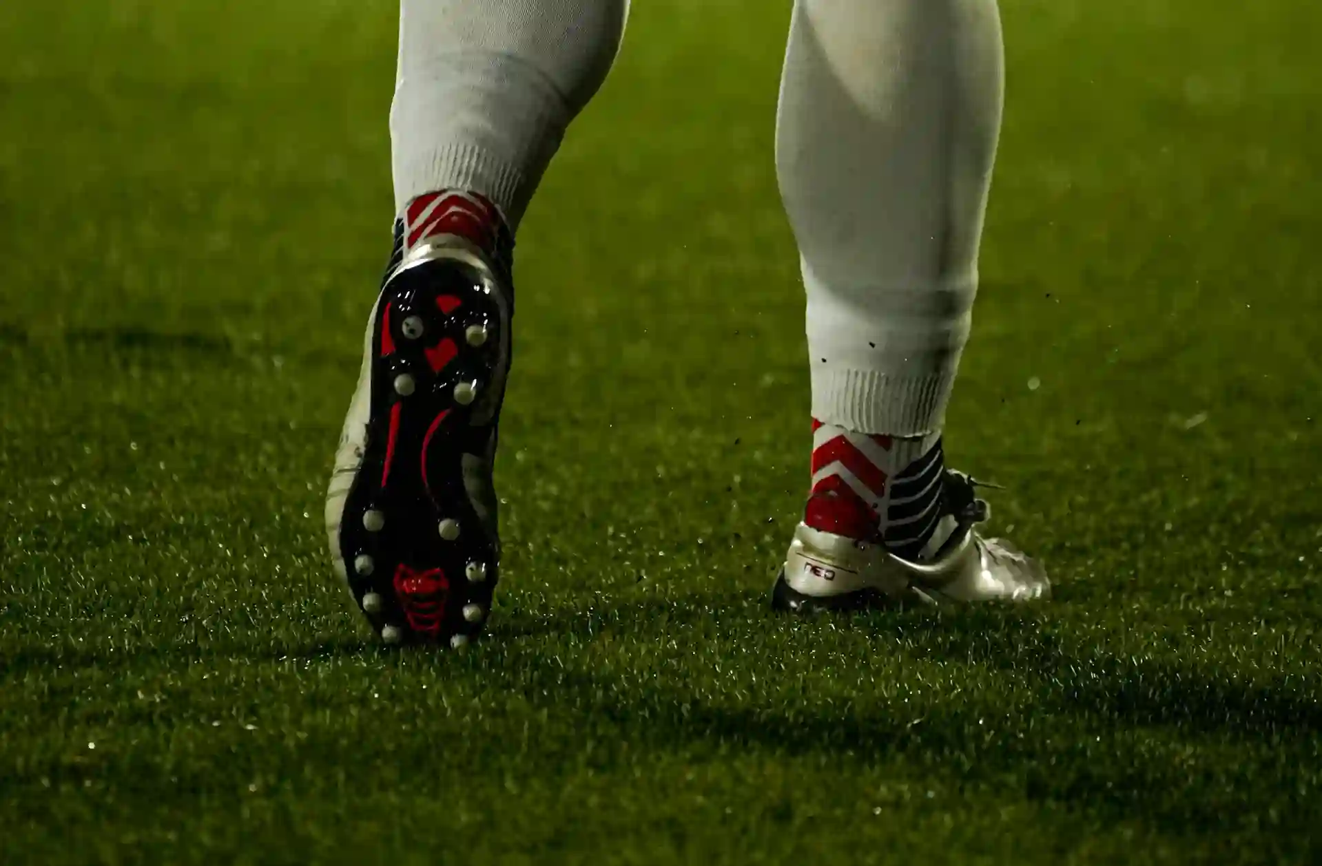 Football player's legs and cleats on the grass