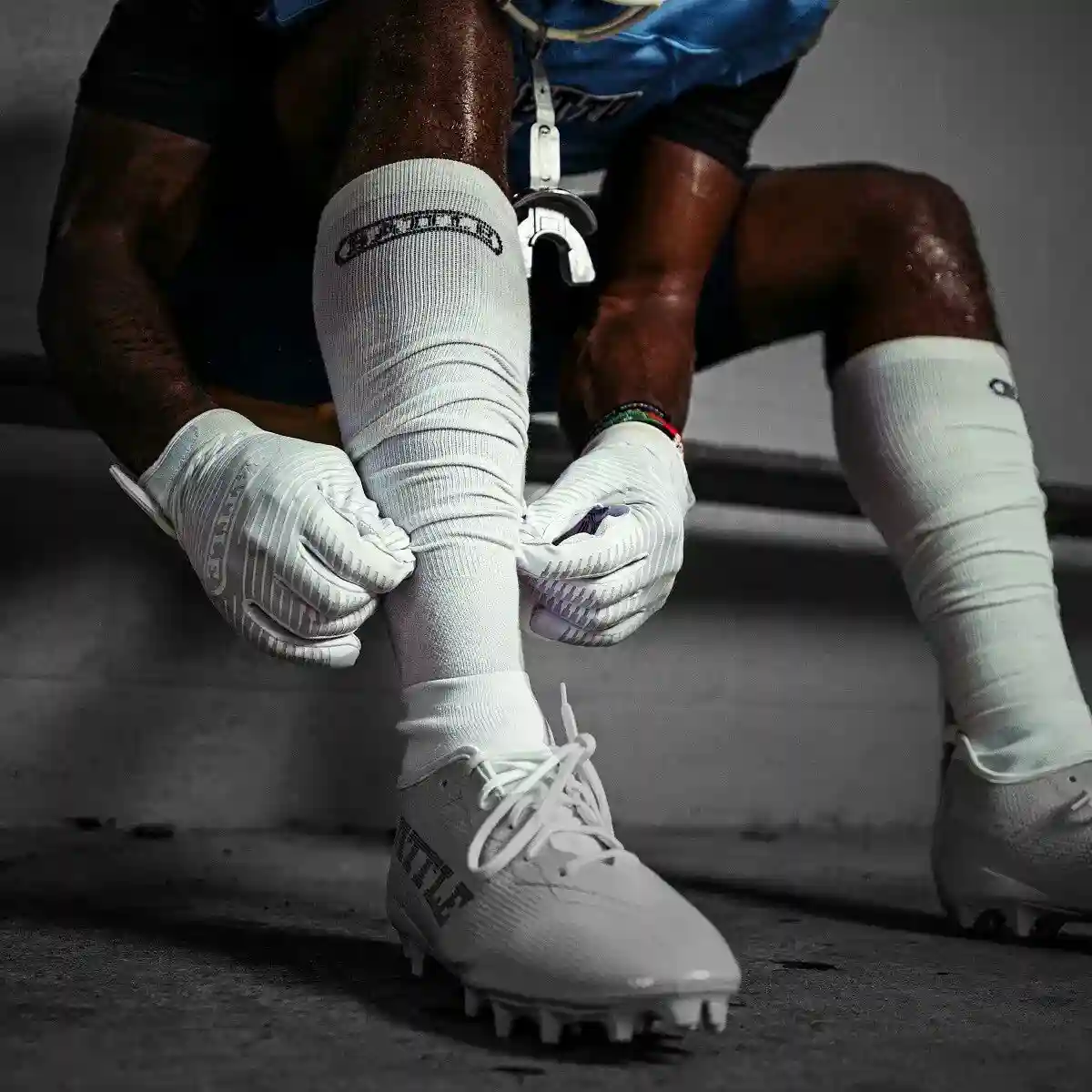 Football player adjusting a white game-day sock