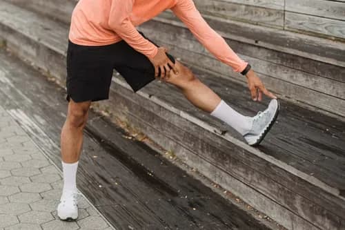 Runner stretching in white running socks