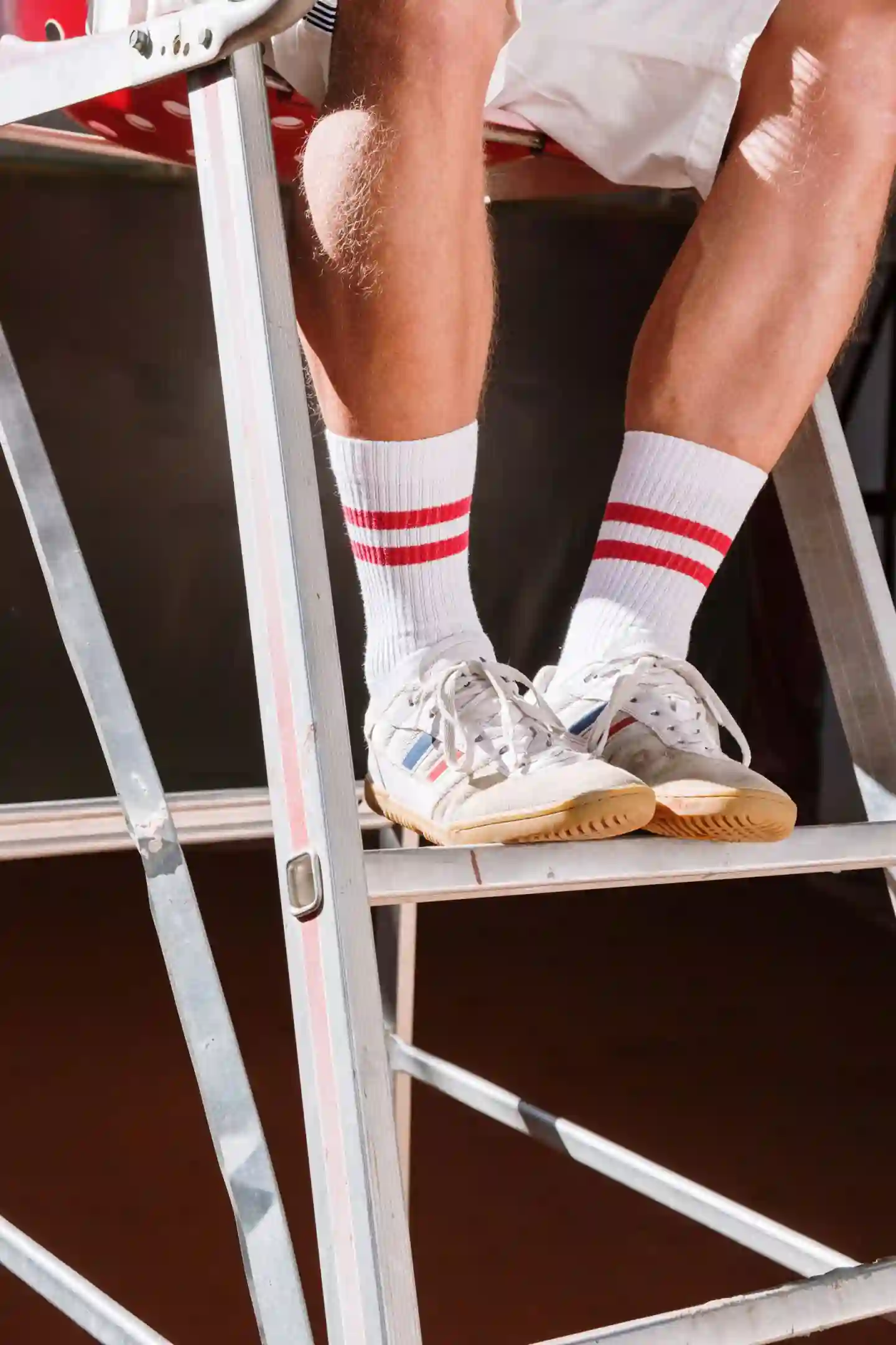 White tennis socks with red stripes and white tennis shoes