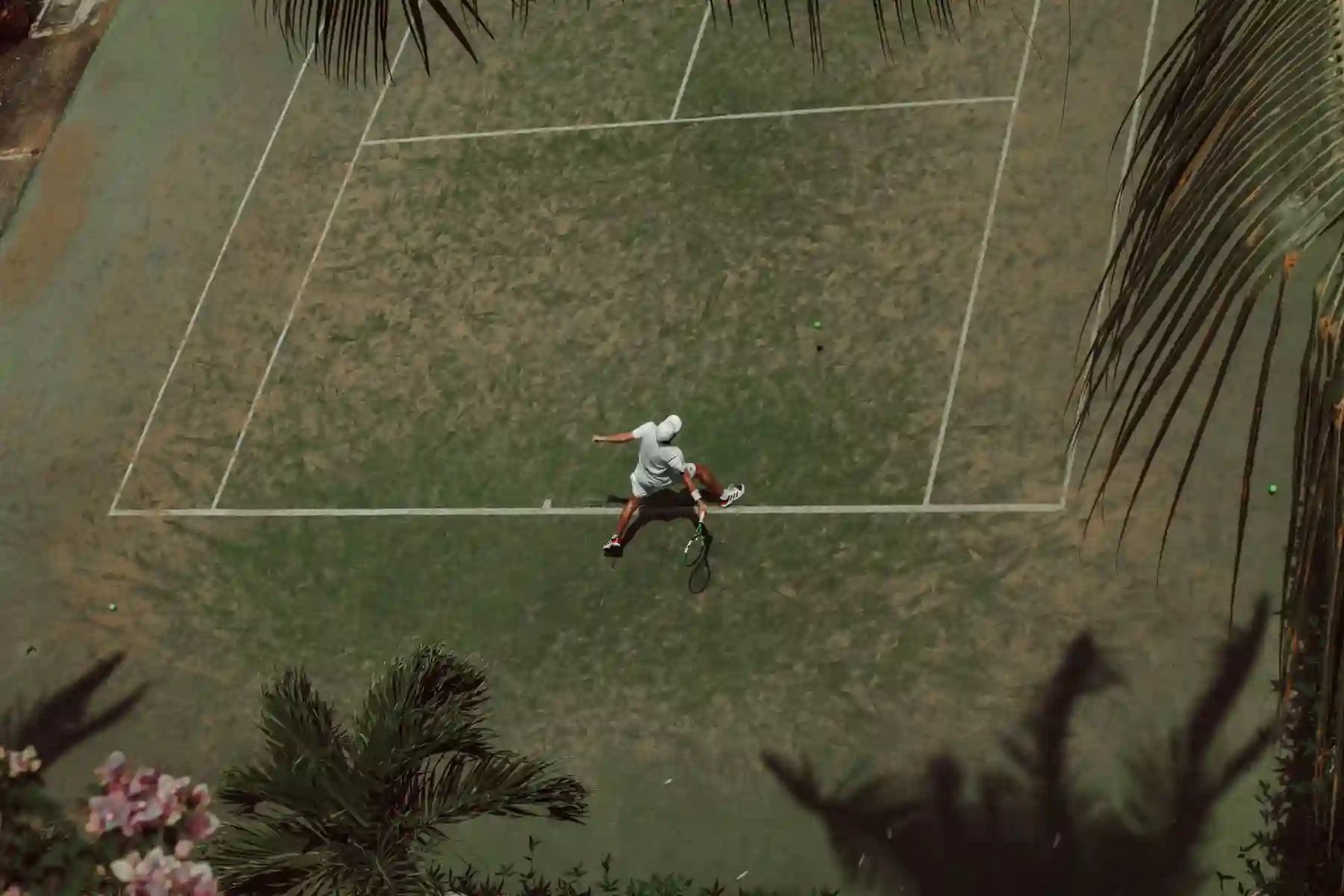 Tennis player on a tropical outdoor court